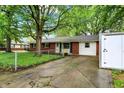 View of a cozy one-story home with a brick and siding exterior, a driveway and a storage shed at 1926 Fairmont Ct, Indianapolis, IN 46229