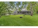 A house with a stone chimney, bay window, and a large backyard with a fire pit at 20322 Wagon Trail Dr, Noblesville, IN 46060