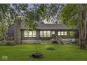 A house with a stone chimney, bay window, and a large backyard with a fire pit at 20322 Wagon Trail Dr, Noblesville, IN 46060