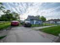 Exterior view of a light blue house with a driveway and well-maintained lawn at 2358 Hovey St, Indianapolis, IN 46218