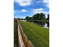 Scenic view of the pond behind the house. Well-manicured lawn with a fence in the foreground at 2509 Cedarmill Dr, Franklin, IN 46131