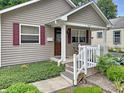 Charming front porch with wooden stairs, white railings, tidy landscaping, and view of the front door at 2612 E Northgate St, Indianapolis, IN 46220