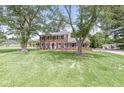 Classic brick two-story home with black shutters, green lawn and mature trees, and detached garage at 3030 E 236Th St, Cicero, IN 46034