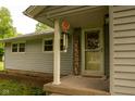 Inviting front porch with 'Welcome' sign, wreath, and decorative wind chimes at 3431 W Mooresville Rd, Indianapolis, IN 46221