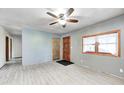 Bright living room featuring wood-look floors, a ceiling fan, and a large window for ample natural light at 3512 N Wakeland Rd, Paragon, IN 46166