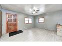 Inviting living room with wood-look floors, a ceiling fan, stone fireplace, and abundant natural light at 3512 N Wakeland Rd, Paragon, IN 46166