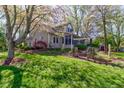 Home showcasing a screened porch, deck, and a beautifully maintained lawn surrounded by trees at 3533 Alexandria Pike, Anderson, IN 46012