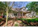 Inviting home with a red front door, covered porch, and mature trees providing shade at 3533 Alexandria Pike, Anderson, IN 46012