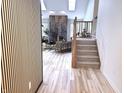 Modern living room features wood floors, a stone fireplace, and a staircase leading to the second floor at 3862 Cornwallis Ln, Carmel, IN 46032