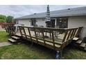 Wooden deck with chairs, table, and an umbrella, perfect for outdoor entertaining and relaxation at 404 E Madison St, Alexandria, IN 46001