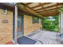 Inviting covered front porch featuring brick columns and wood flooring at 410 E Southport Rd, Indianapolis, IN 46227