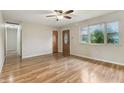 Bright living room with hardwood floors, ceiling fan, and natural light from a large window at 410 E Southport Rd, Indianapolis, IN 46227