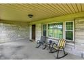 Inviting covered front porch with stone wall, featuring seating area and views of the surrounding landscape at 4125 S Post Rd, Indianapolis, IN 46239
