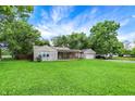 Well-maintained single story home with stone and siding exterior, plus a lush front yard and mature trees at 4125 S Post Rd, Indianapolis, IN 46239