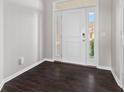 Inviting foyer features dark hardwood floors, a white front door with sidelights, and neutral wall paint at 4539 Maldenhair Dr, Indianapolis, IN 46239