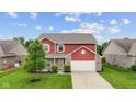 Beautiful aerial view of a red two-story home with lush green lawn in a peaceful neighborhood at 4683 W Lawrence Way, New Palestine, IN 46163