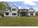 Charming white brick two-story home featuring black trim, black awnings, and a well-maintained lawn at 4808 Lakeview Dr, Greenwood, IN 46143