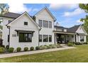 Beautiful white brick home featuring black trim, manicured landscaping, and a welcoming covered porch at 4808 Lakeview Dr, Greenwood, IN 46143