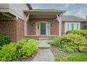 Inviting brick home entryway with covered porch and manicured landscaping at 4949 Jennings Dr, Carmel, IN 46033
