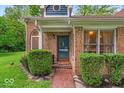 Charming front entrance with brick pathway, surrounded by manicured bushes and a classic brick facade at 5558 Spicebush Dr, Indianapolis, IN 46254