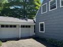 Side view of home with two car garage, wooden siding, and mature trees at 5889 Crestview Ave, Indianapolis, IN 46220