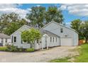 This house features light blue siding, a basketball hoop over the garage, and a lovely tree in the front yard at 604 Alexandria Pike, Anderson, IN 46012