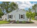 Inviting single-story home with light blue siding, black shutters, and a well-maintained front yard, set against a clear blue sky at 604 Alexandria Pike, Anderson, IN 46012