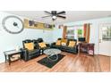 Cozy living room with leather couches, wood-look flooring, and a ceiling fan at 6553 Black Antler Dr, Indianapolis, IN 46217