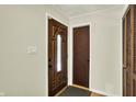 Inviting entryway with wood-grain doors and neutral walls, a light switch, and a closet with bifold doors at 741 Fairway Dr, Indianapolis, IN 46260