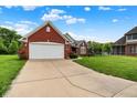Charming single-story red brick home featuring an attached two-car garage and well-maintained lawn at 7521 Kilbarron Cir, Indianapolis, IN 46217