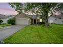 Charming brick home featuring a well-maintained lawn and mature tree, enhancing its curb appeal at 7724 Blackthorn Dr, Indianapolis, IN 46236