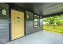 Covered porch with a bright yellow front door, sidelights, and black trim at 805 N Euclid Ave, Indianapolis, IN 46201