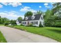 Lovely white home with black shutters, a red front door, and lush green lawn at 8301 E County Road 801 S, Plainfield, IN 46168