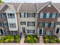 An aerial view shows three brick and tan townhomes with symmetrical windows and well-kept landscaping at 9090 Demarest Dr, Fishers, IN 46038