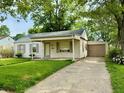 Inviting single-story home with a covered porch, attached garage, and a lush green lawn at 910 Lonsvale Dr, Anderson, IN 46013