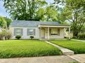 Quaint single-story home with a covered front porch and well-maintained landscaping at 910 Lonsvale Dr, Anderson, IN 46013