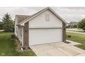 Two-car garage with a white door and well-kept lawn at 933 Curlew Ln, Greenwood, IN 46143