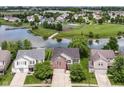 Aerial view of a brick two-story home in a neighborhood with a pond and community park at 9358 W Rising Sun Dr, Pendleton, IN 46064
