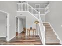 Inviting foyer featuring a staircase, stylish lighting, and rich wood-look flooring at 9754 Bradford Knoll Dr, Fishers, IN 46037