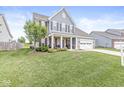 Inviting two-story home showcasing a manicured lawn, classic shutters, and a welcoming front porch at 10284 Legacy Dr, Brownsburg, IN 46112
