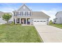 Beautiful two-story home with a lush green lawn, a long driveway, and classic architectural details at 10284 Legacy Dr, Brownsburg, IN 46112