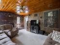 Cozy living room featuring wood paneled walls, brick fireplace, and comfortable seating at 10307 Wilson Rd, Brownsburg, IN 46112