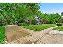 Long driveway leading to a charming two-story home with well-maintained landscaping and mature trees at 12961 Limberlost Dr, Carmel, IN 46033