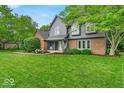Charming two-story home featuring a well-manicured lawn, beautiful landscaping, and a welcoming front porch at 12961 Limberlost Dr, Carmel, IN 46033