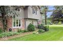 View of the home's entrance, showcasing brickwork, siding, manicured bushes, and a small fenced garden area at 13297 Highland Springs Dr, McCordsville, IN 46055