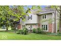 Attractive exterior with brick accents, neutral siding, a small fenced area, and lush landscaping at 13297 Highland Springs Dr, McCordsville, IN 46055