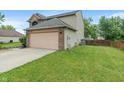 Side view of a well-maintained home featuring a spacious two-car garage and a lush green lawn at 1408 Snead Cir, Avon, IN 46123