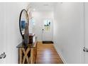 Bright entryway with hardwood floors, decorative mirror, stylish console table and view of front door at 15387 Alperton Rd, Fishers, IN 46037