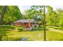 The home's rear features a cozy deck and solar panels, set against the backdrop of a serene pond and natural landscape at 1633 W 200 North, Greenfield, IN 46140