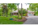 A charming brick home with an attached garage, surrounded by mature trees, lush lawn, and meticulous landscaping at 1633 W 200 North, Greenfield, IN 46140